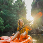 Tropenreisen : Frau paddelt im Dschungel