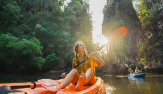 Tropenreisen : Frau paddelt im Dschungel