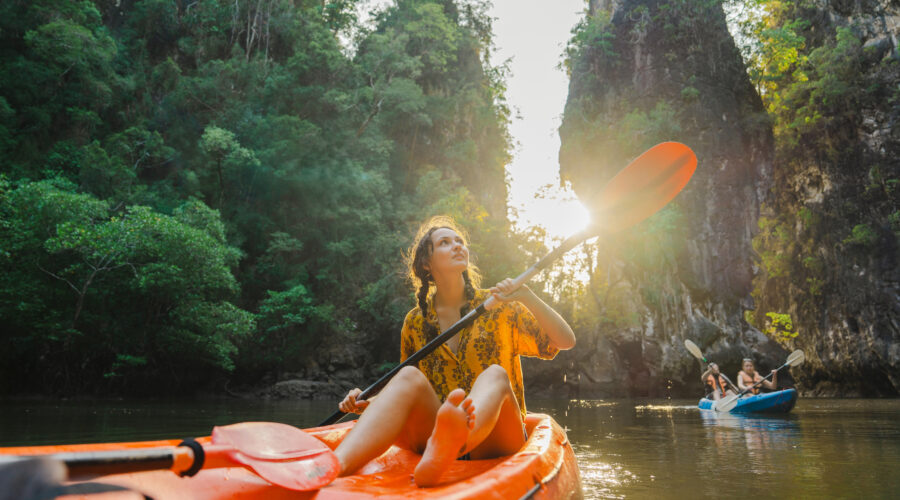 Tropenreisen : Frau paddelt im Dschungel