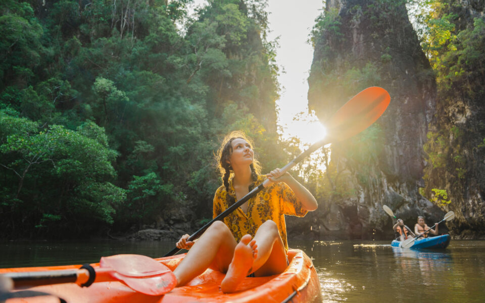 Tropenreisen : Frau paddelt im Dschungel