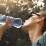 Frau trinkt aus flasche