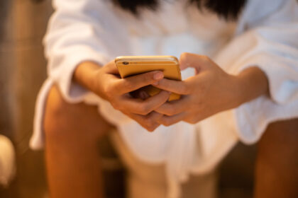 Mit Handy auf der Toilette